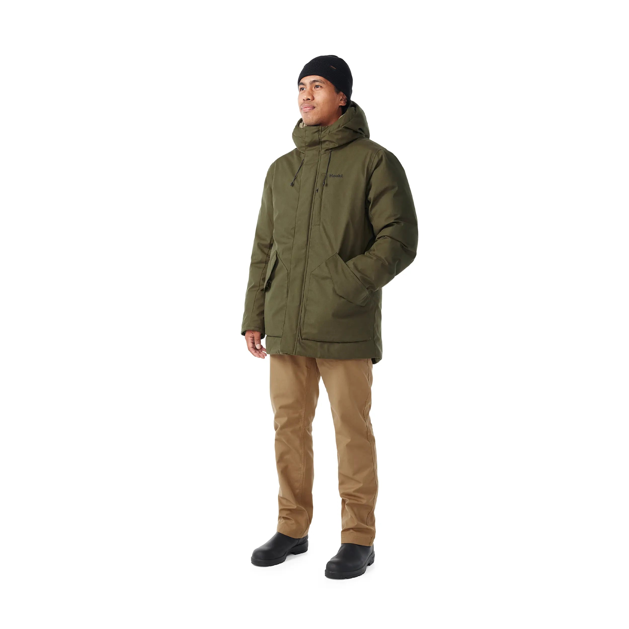 Person wearing a green jacket and brown pants on a white background